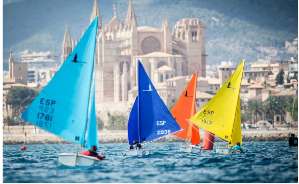 The Hansa 303 fleet competing in front of Palma Cathedral during the PalmaVela regatta